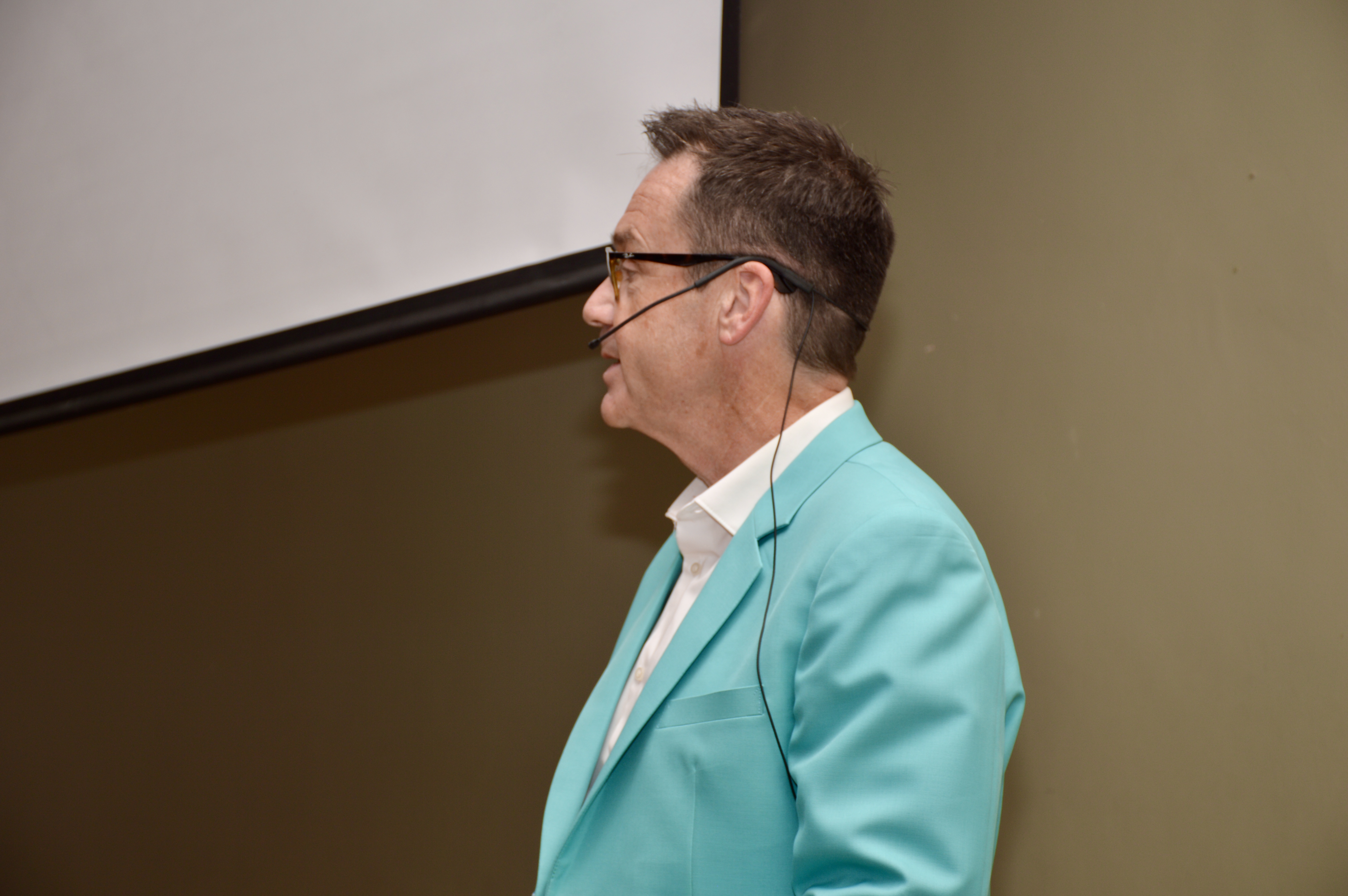 Paul Carter speaking, wearing his teal jacket